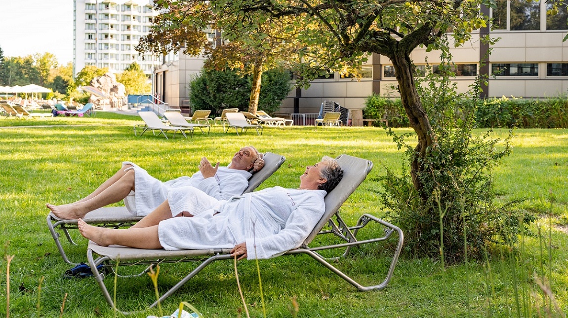Paar entspannt auf Liegen auf der Liegewiese der Johannesbad Therme