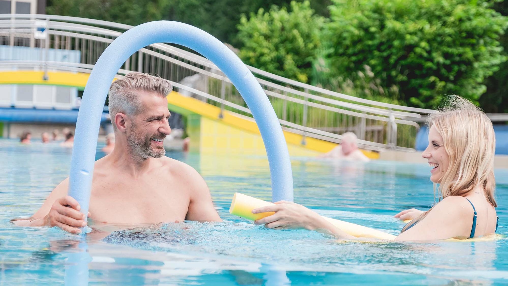 Zwei Personen mit Poolnudel im Wasser der Johannesbad Therme